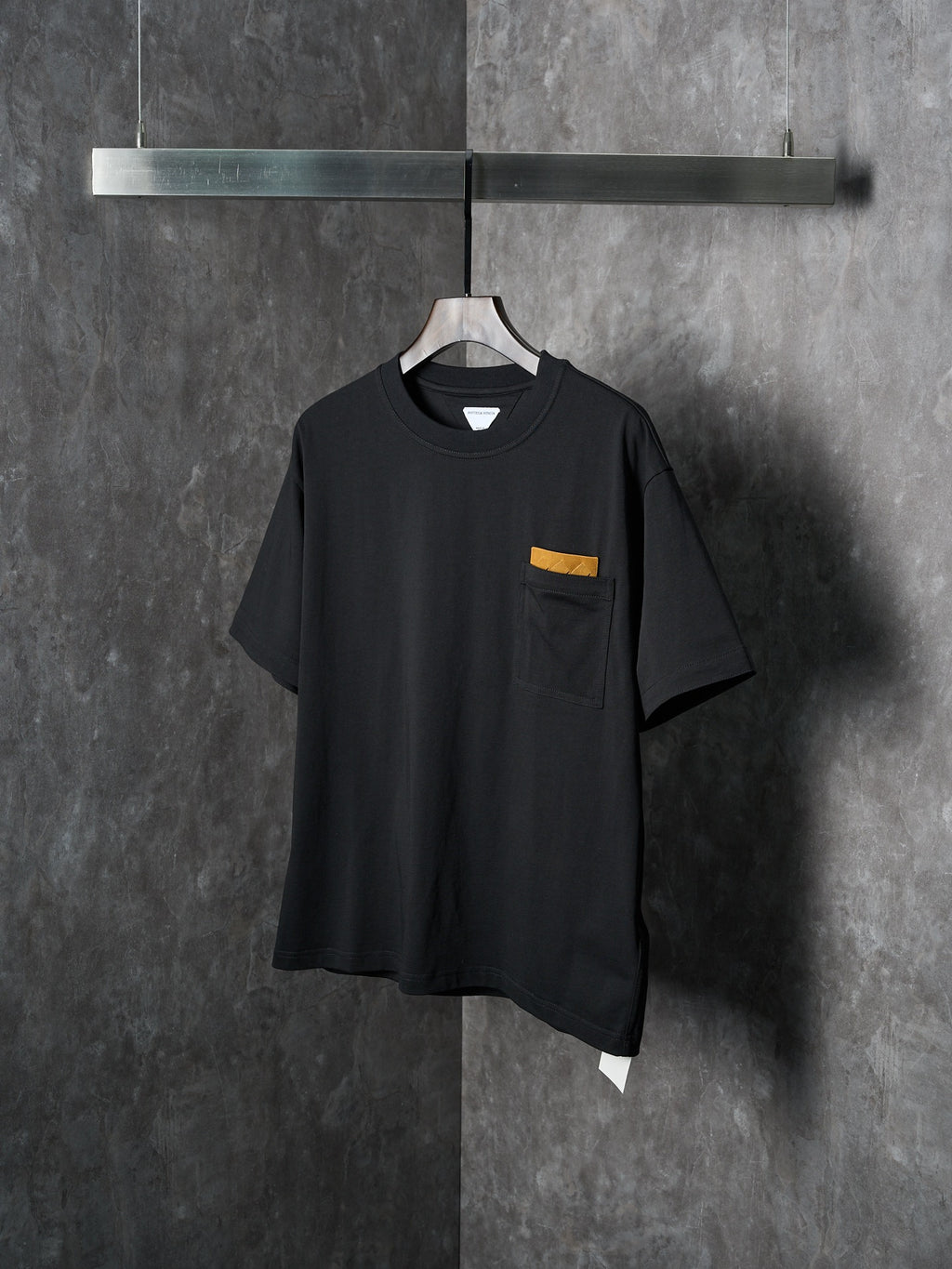 Black short-sleeve T-shirt with chest pocket and small yellow accent tab