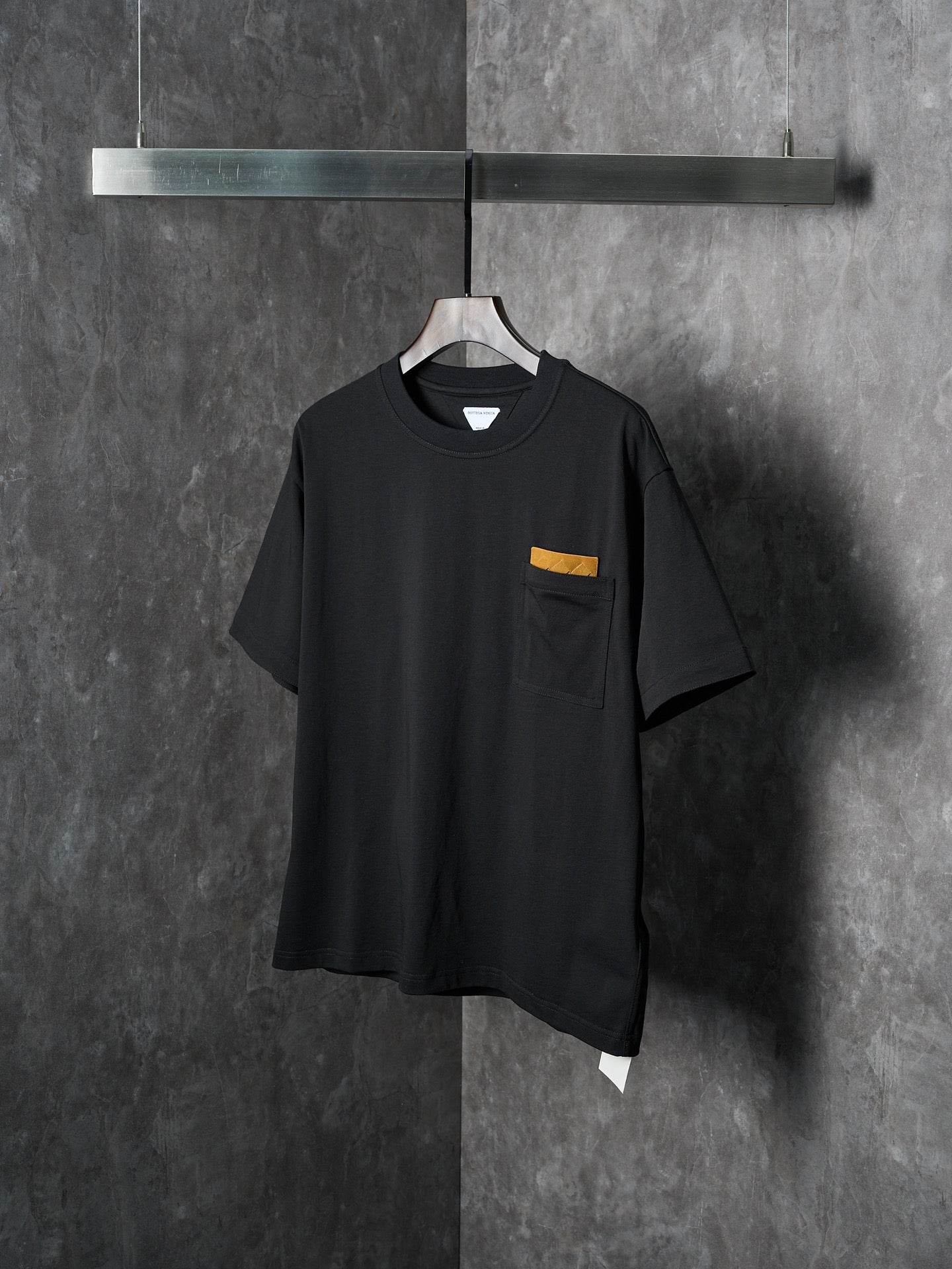 Black short-sleeve T-shirt with chest pocket and small yellow accent tab