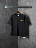Black short-sleeve T-shirt with chest pocket and small yellow accent