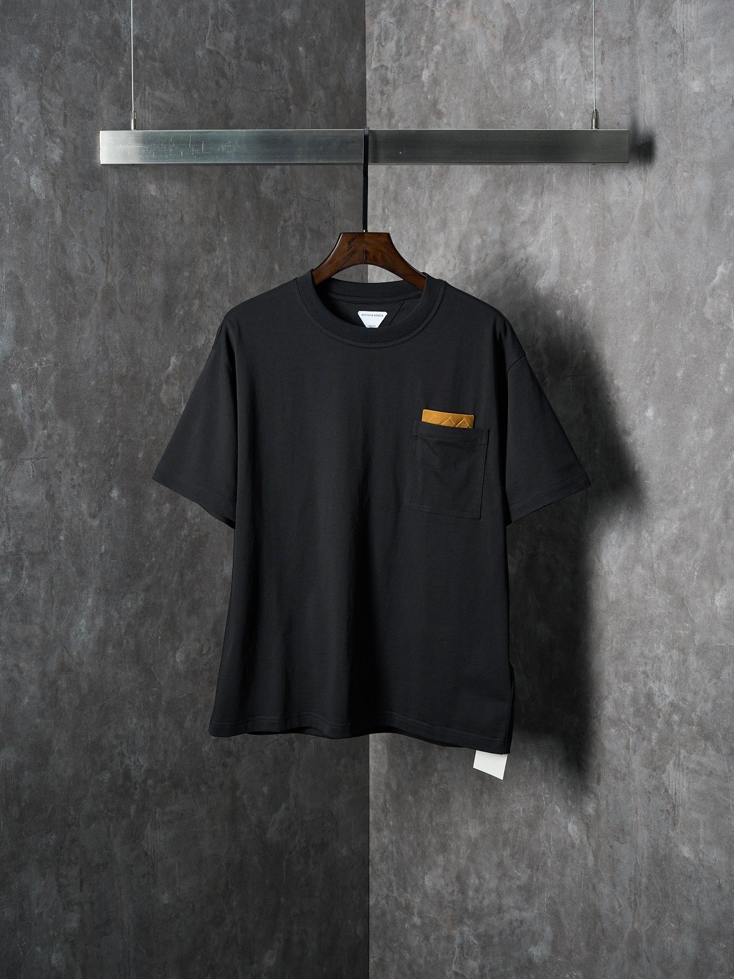 Black short-sleeve T-shirt with chest pocket and small yellow accent