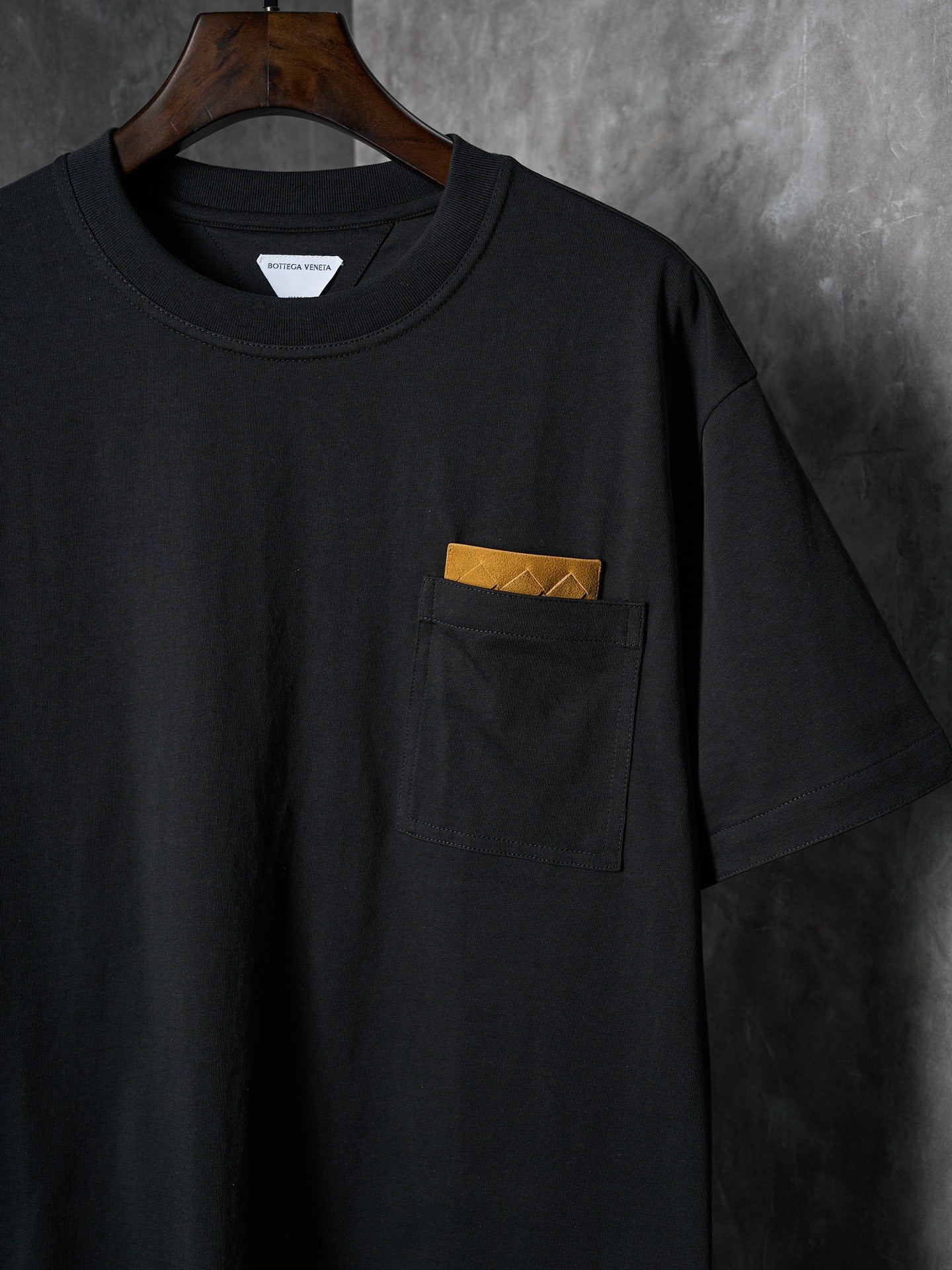 Black short-sleeve T-shirt with chest pocket and yellow accent label