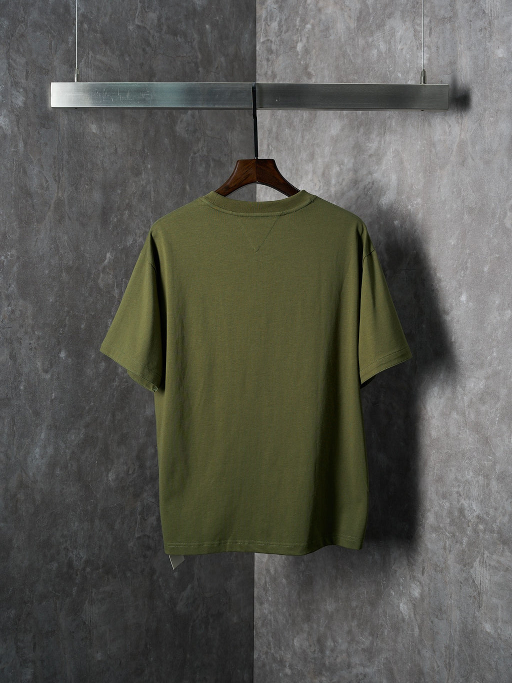 Olive green short-sleeve T-shirt on hanger, back view