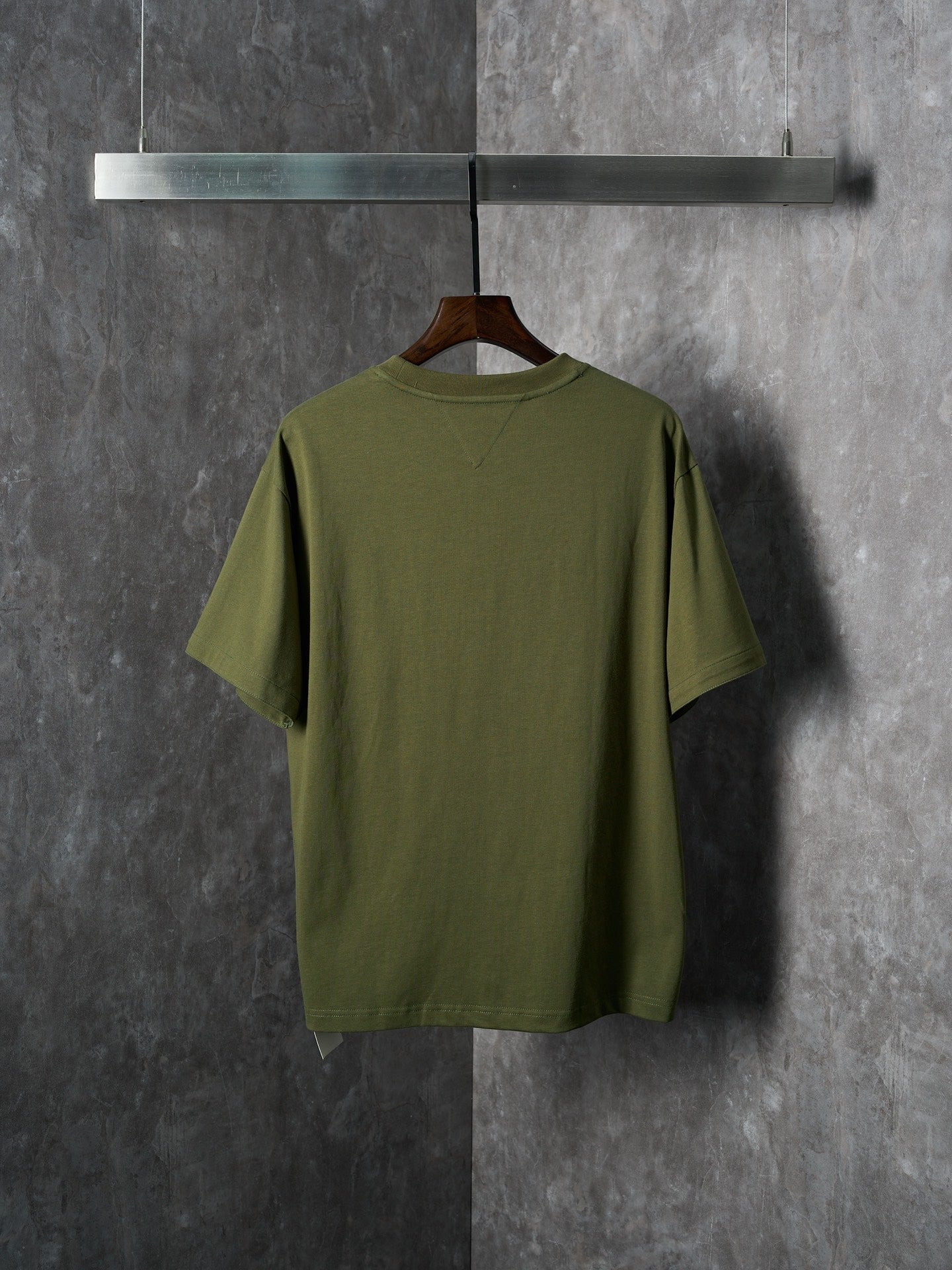 Olive green short-sleeve T-shirt on hanger, back view