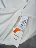 Off-white T-shirt with Bottega Veneta hang tags attached near the fabric