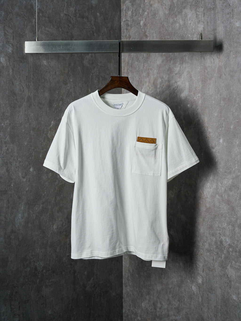 Off-white T-shirt with crew neck and chest pocket featuring a brown embroidered patch
