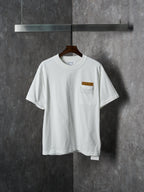 Off-white T-shirt with crew neck and chest pocket featuring a brown embroidered patch