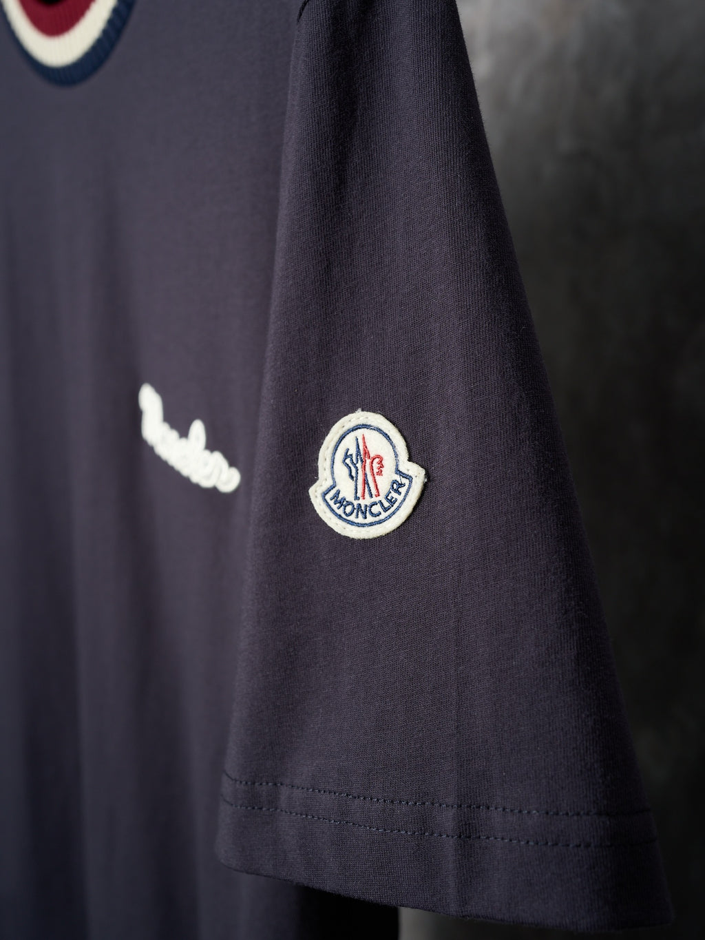 Navy T-shirt sleeve with circular logo patch