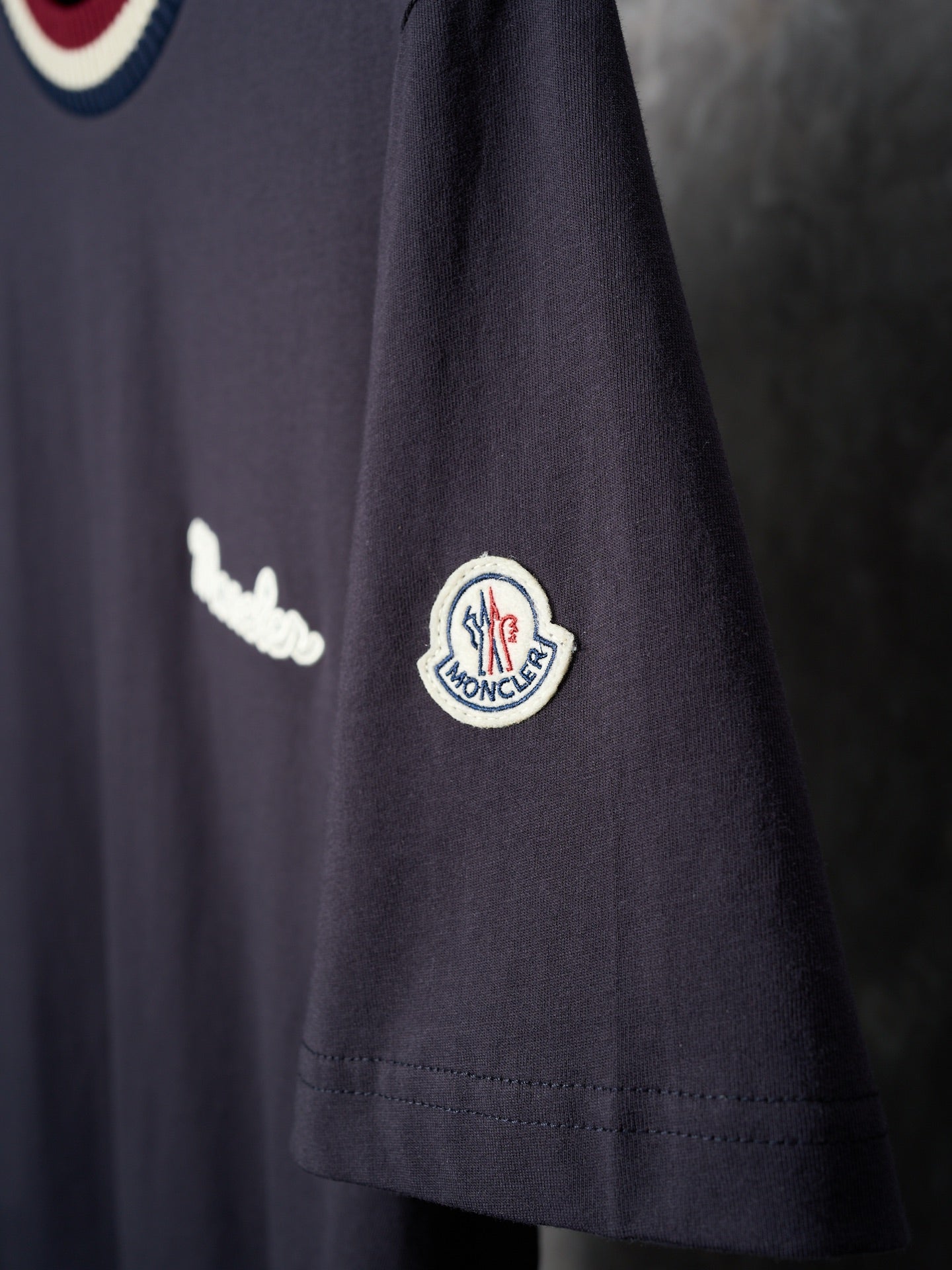 Navy T-shirt sleeve with circular logo patch