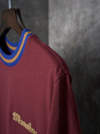 Burgundy T-shirt side view with striped crew neck and gold script logo