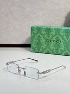 Gucci rectangular eyeglasses with dark-tinted lenses, silver-tone frame, and beaded temples