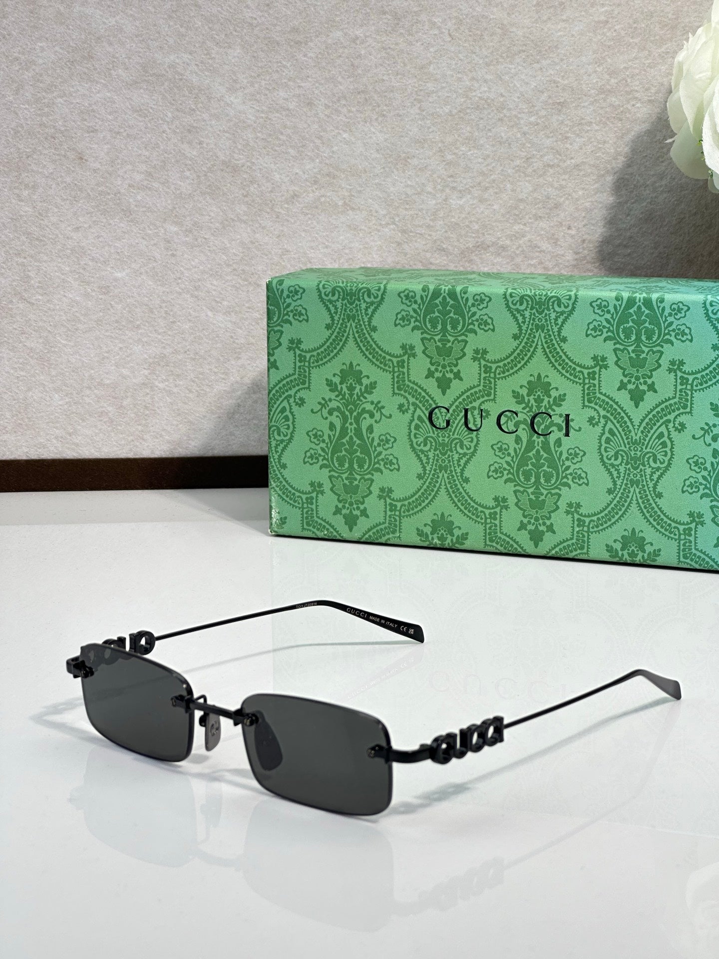 Gucci rectangular sunglasses with dark lenses, black frame, and beaded temple detail
