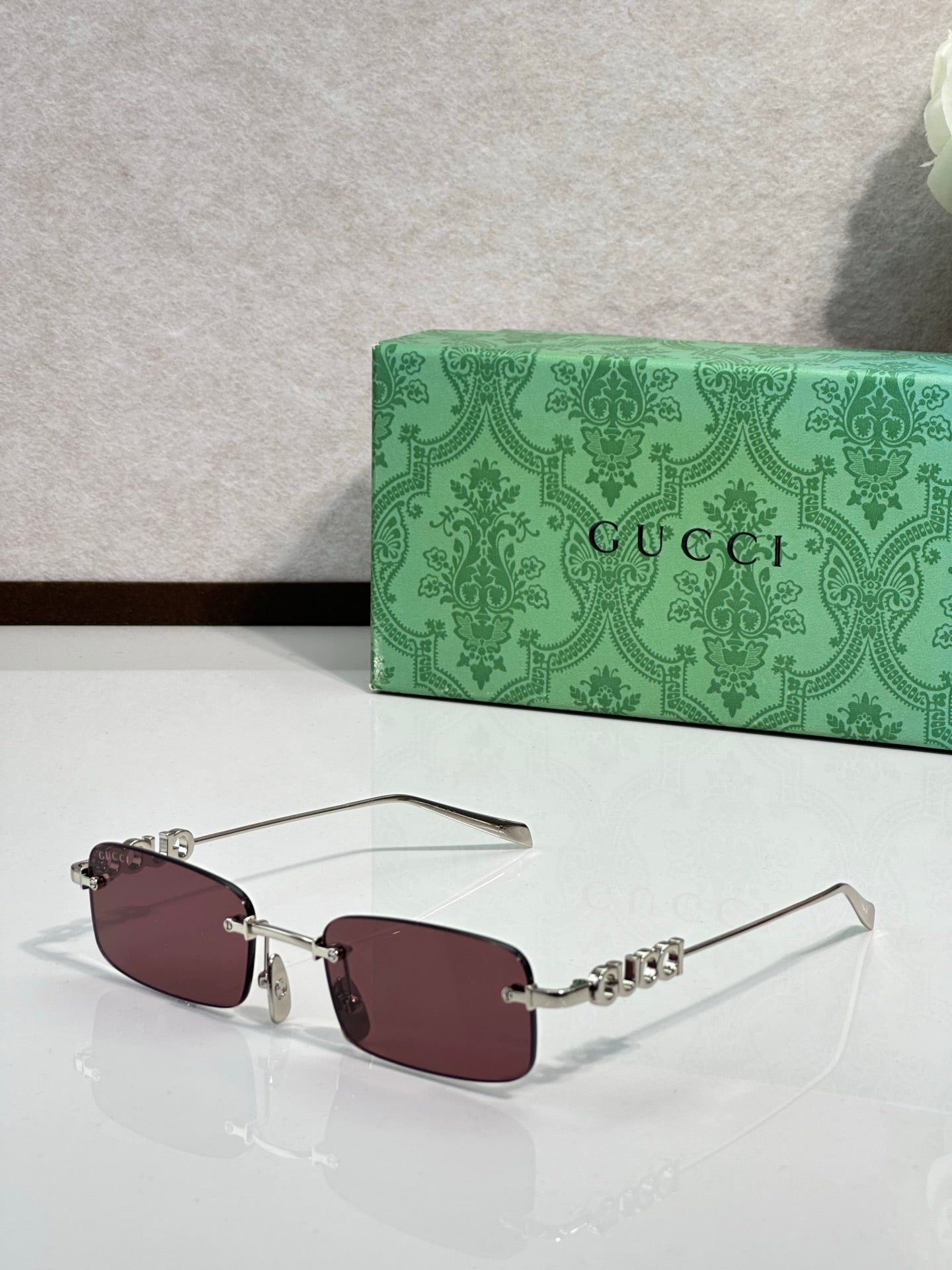 Gucci rectangular sunglasses with burgundy lenses, maroon frame, and beaded temple detail