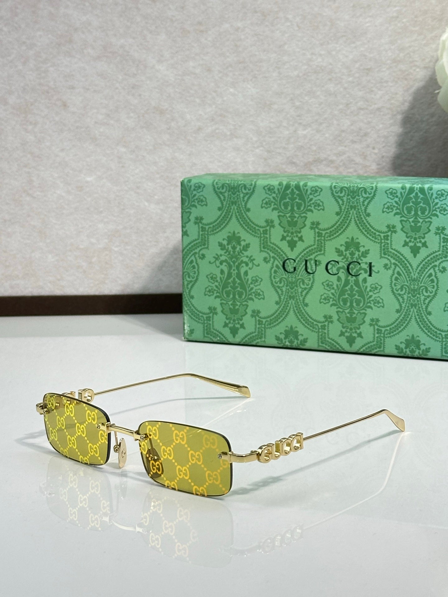 Gucci rectangular sunglasses with yellow lenses, gold-tone frame, and beaded temple detail