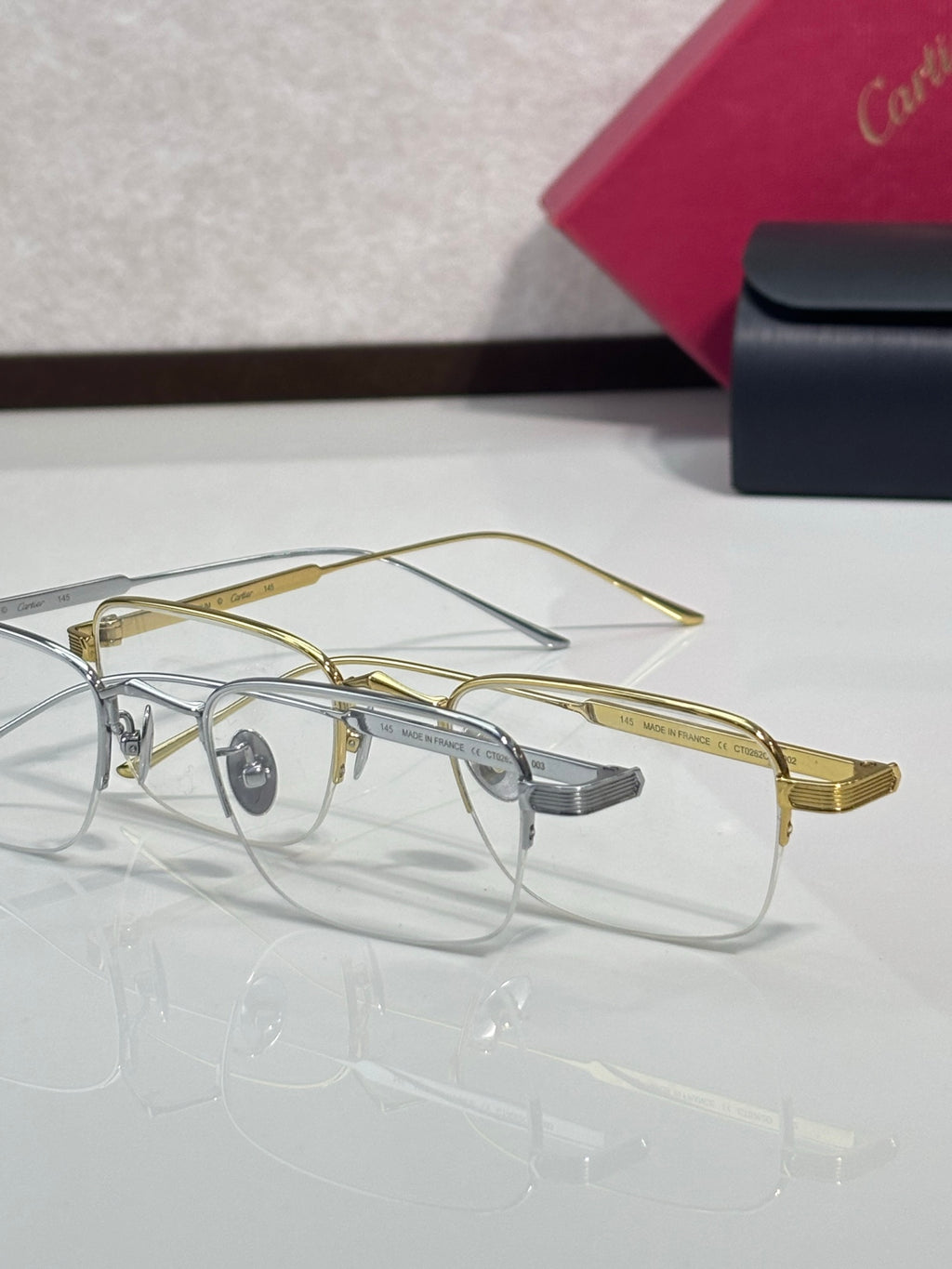 Clear-lens eyeglasses with gold metal rims and gray nose bridge