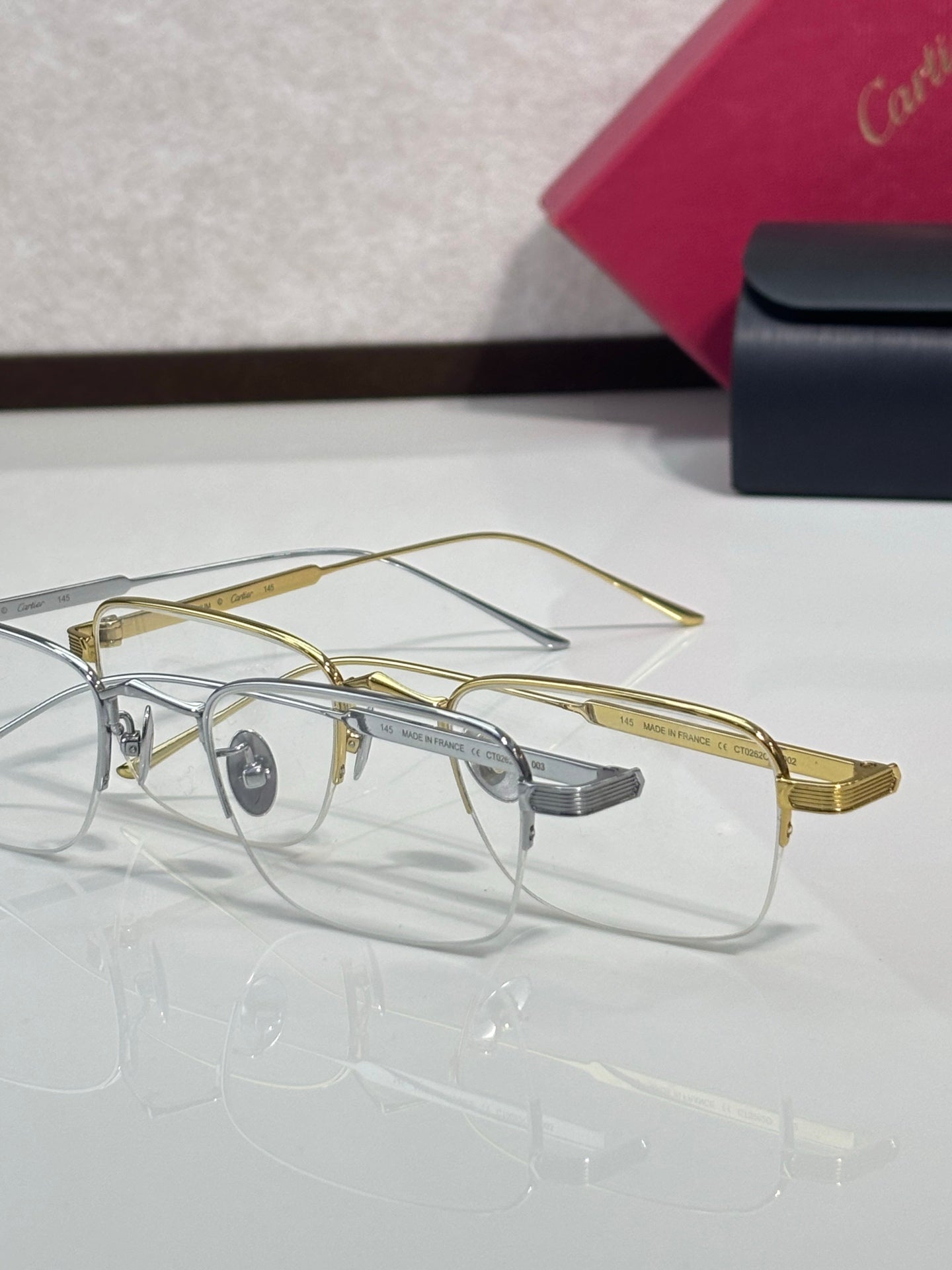 Clear-lens eyeglasses with gold metal rims and gray nose bridge