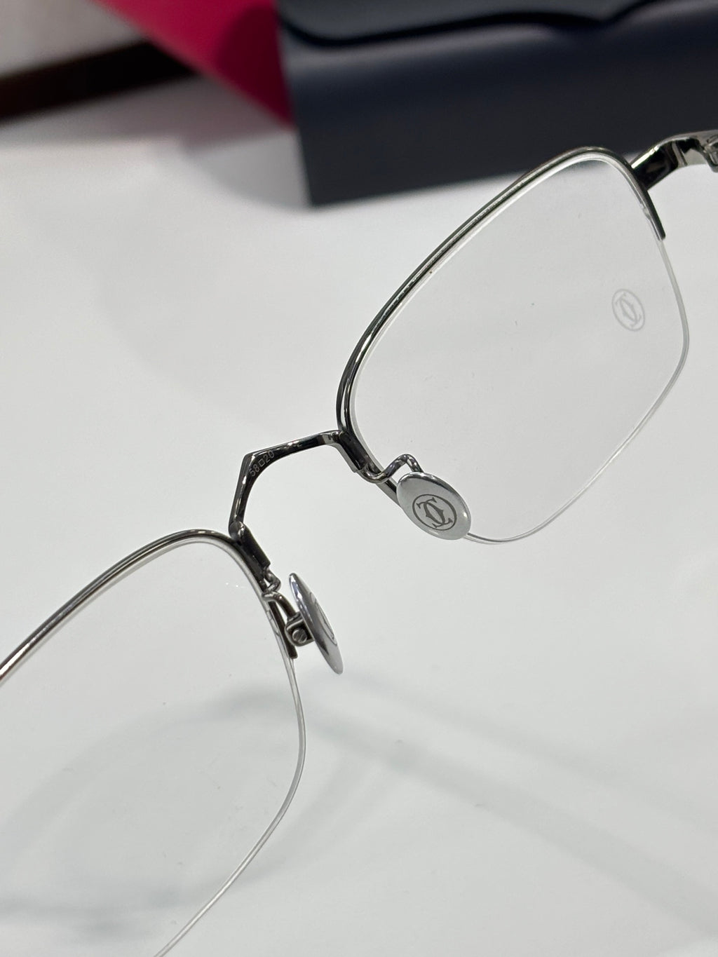 Clear-lens eyeglasses close-up with silver metal frame and hinge detail