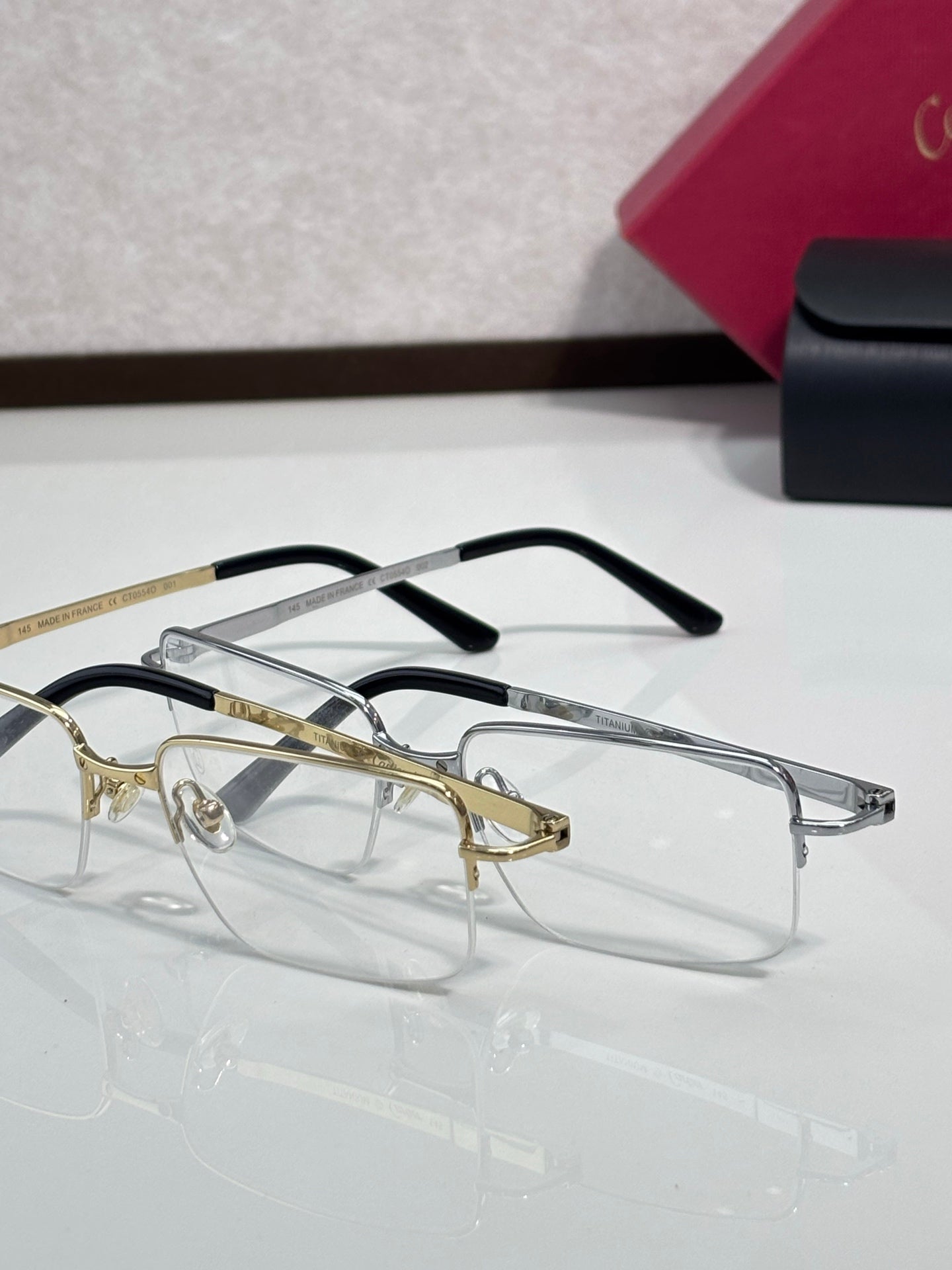 Cartier eyeglasses set with gold and black frames, clear rectangular lenses