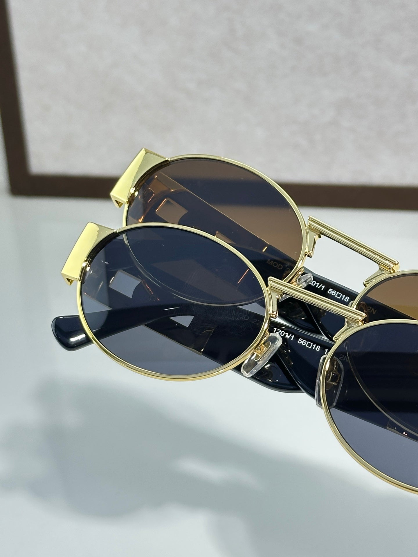 Versace round sunglasses with gold frame and dark blue lenses, side profile view