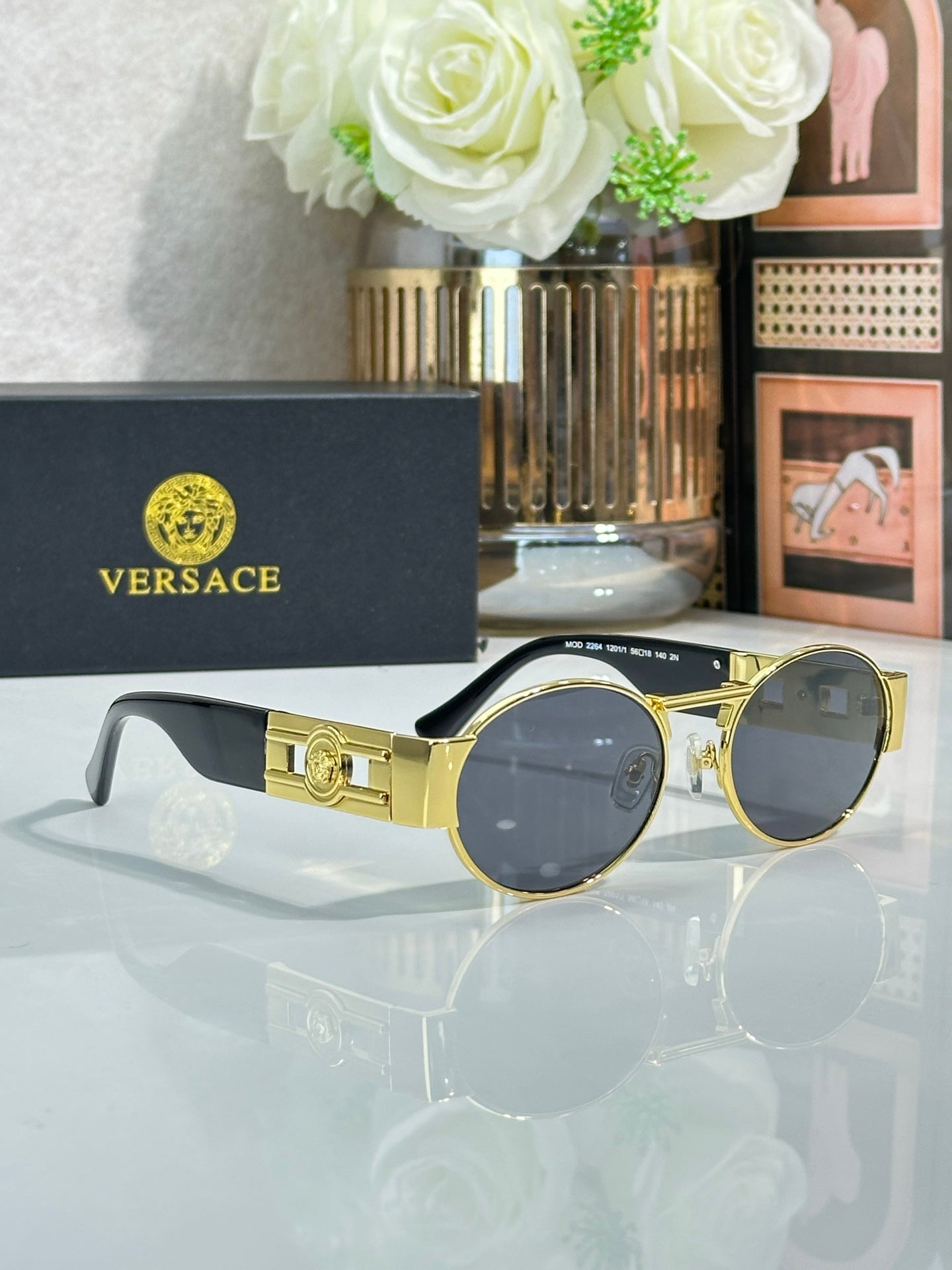Versace round sunglasses with gold frame and dark lenses, ornate bridge hardware