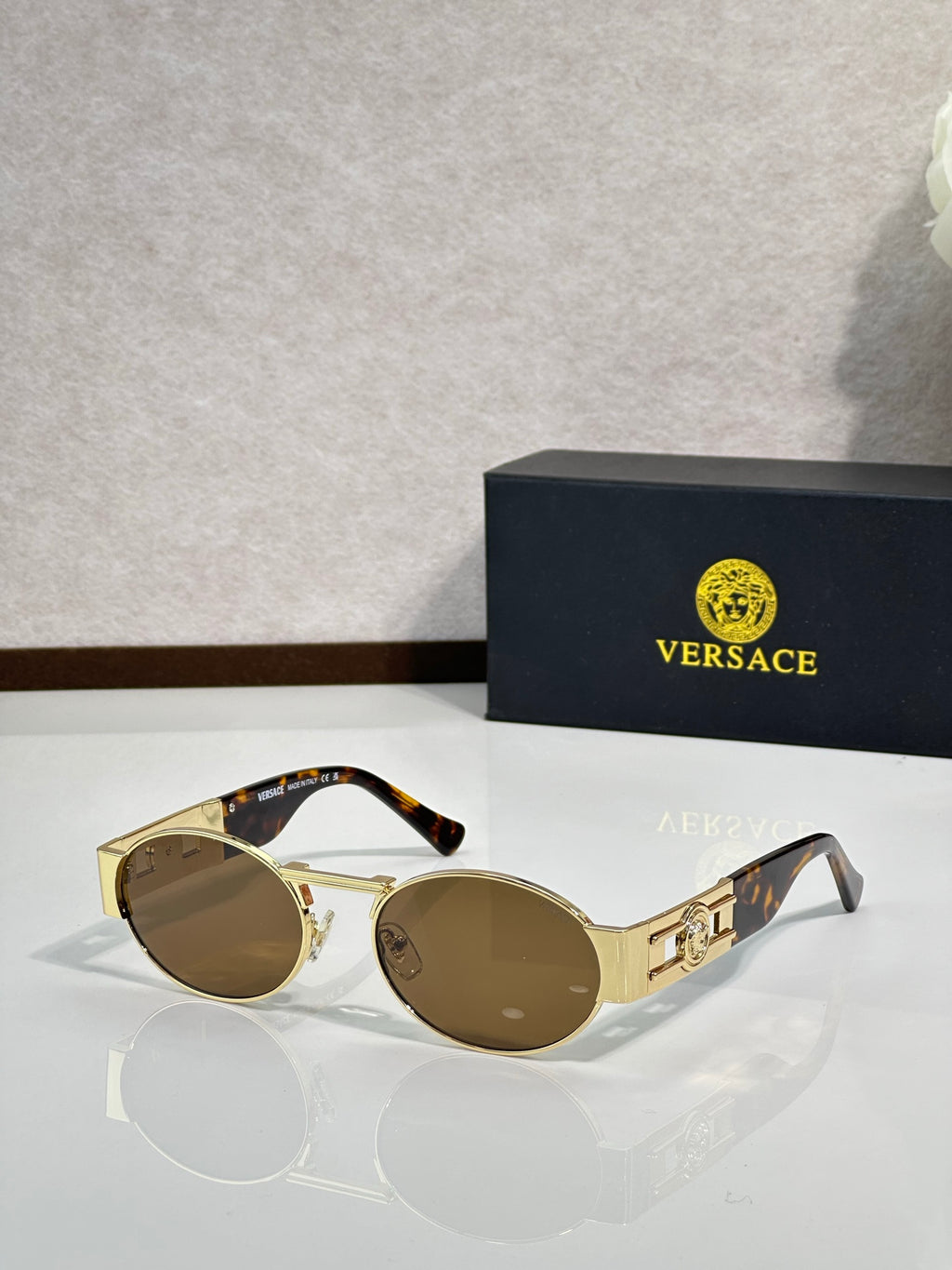 Versace round sunglasses with gold frame and brown lenses, curved temple arms