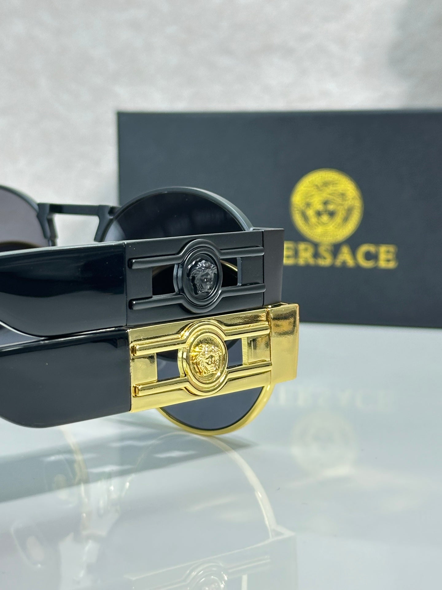 Versace sunglasses hinge detail with gold emblem and dark frame arms