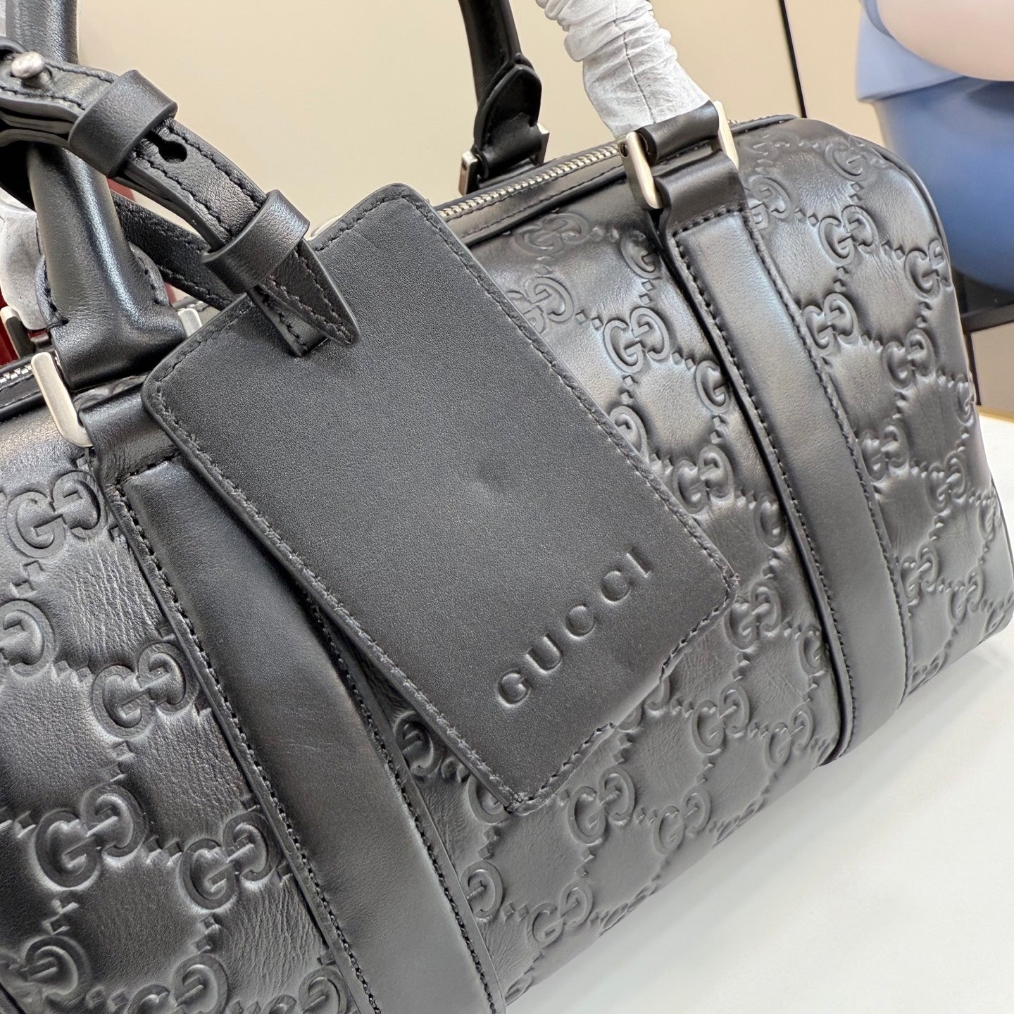 Gucci bag with embossed GG pattern, front flap and top handles