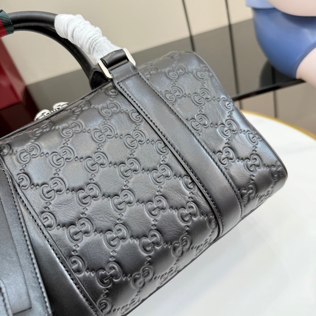 Dark gray GG monogram handbag side with stitched leather trim and top handle