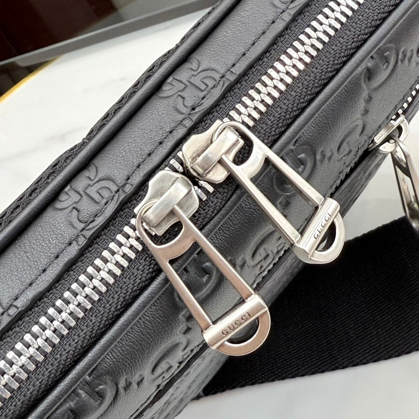 Gucci crossbody bag hardware close-up with silver buckles and zipper