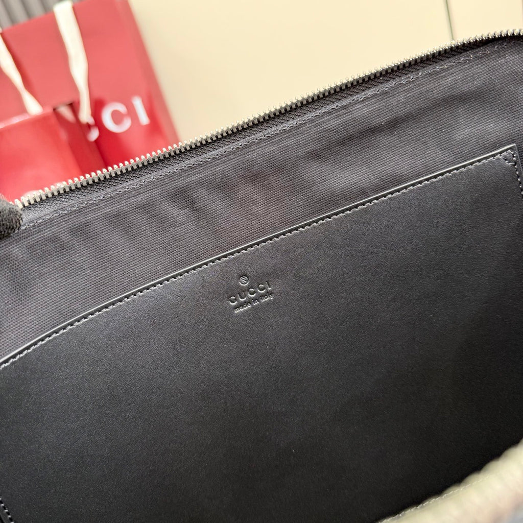 Gucci pouch bag interior close-up showing small brand logo on dark lining.