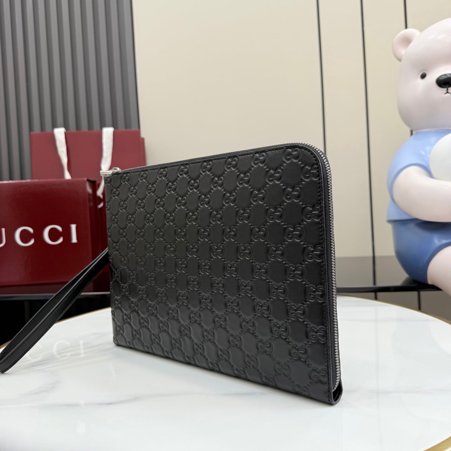 Black Gucci GG-pattern small pouch bag with wrist strap and zipper top