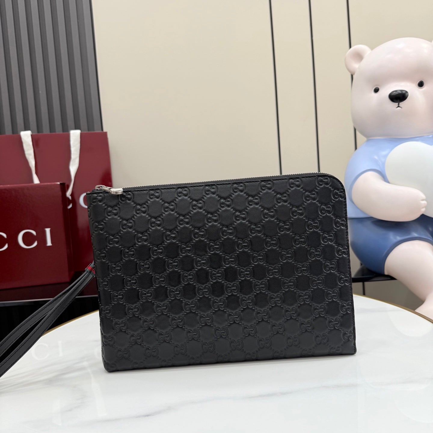 Gucci GG monogram crossbody pouch bag, dark with zip top and chain strap.