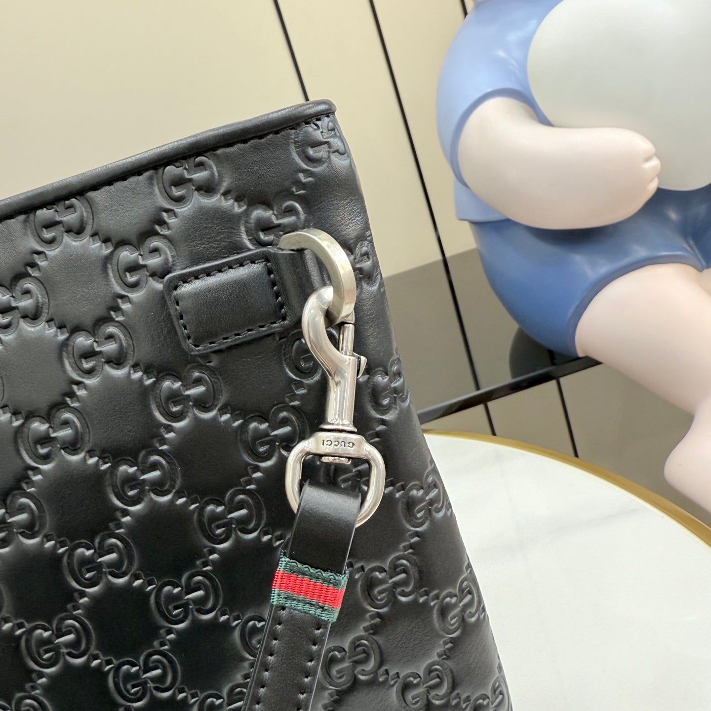 Gucci dark gray GG-embossed bag with metal D-ring and web strap charm