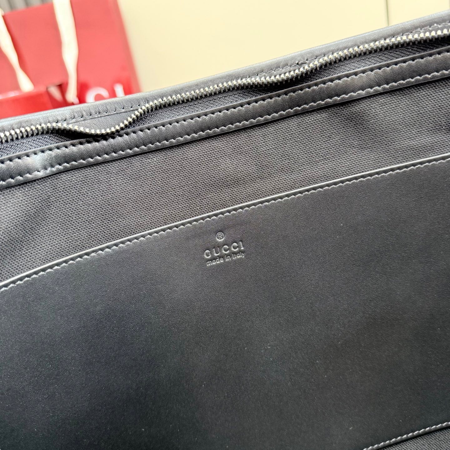 Gucci bag exterior with small leather logo stamp and stitched trim