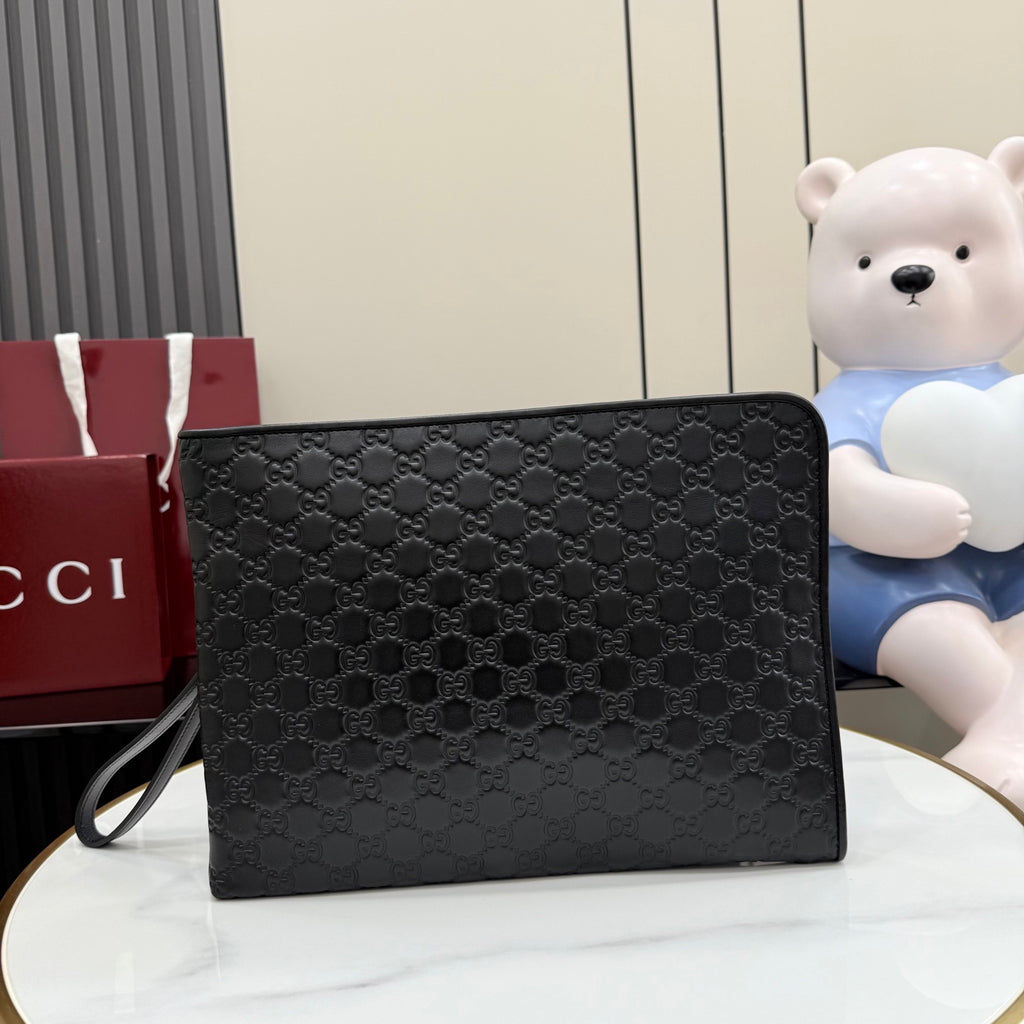 Gucci small bag, dark GG-pattern canvas with flap and wrist strap.