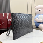 Gucci bag with dark gray monogram print, zip closure, and wrist strap