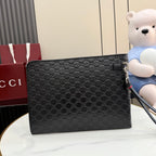 Gucci small bag, dark GG-pattern canvas with flap closure and zipper pull.