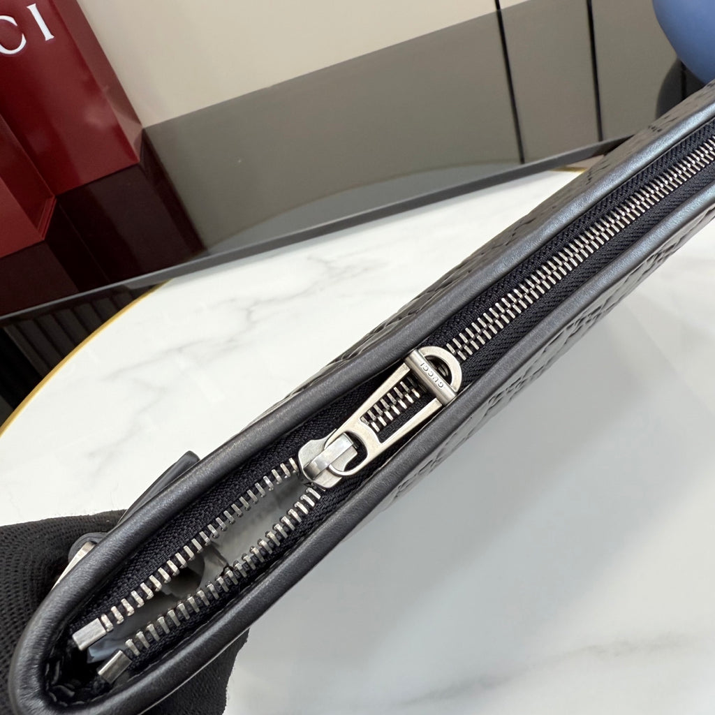 Gucci small bag, zipper close-up with silver track and stitched leather edges.