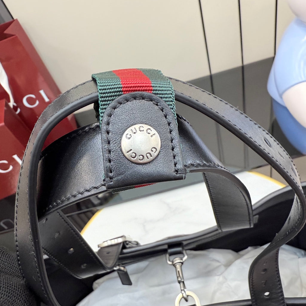 Gucci small tote bag strap close-up with striped pull tab and snap hardware