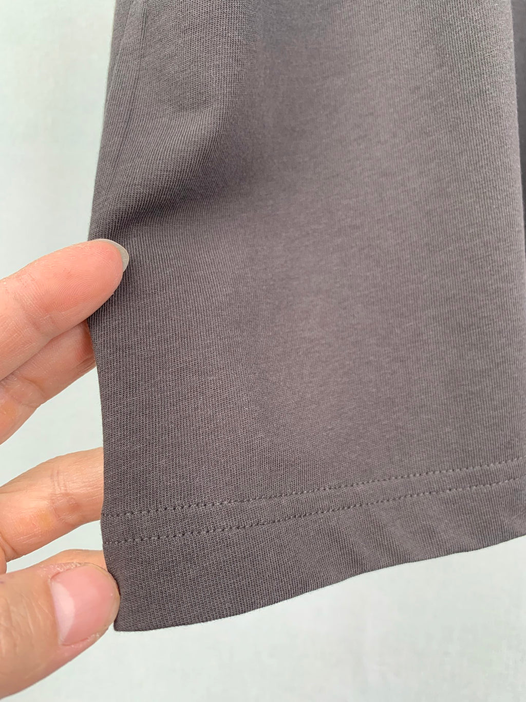 Dark T-shirt side seam and hem stitching close-up