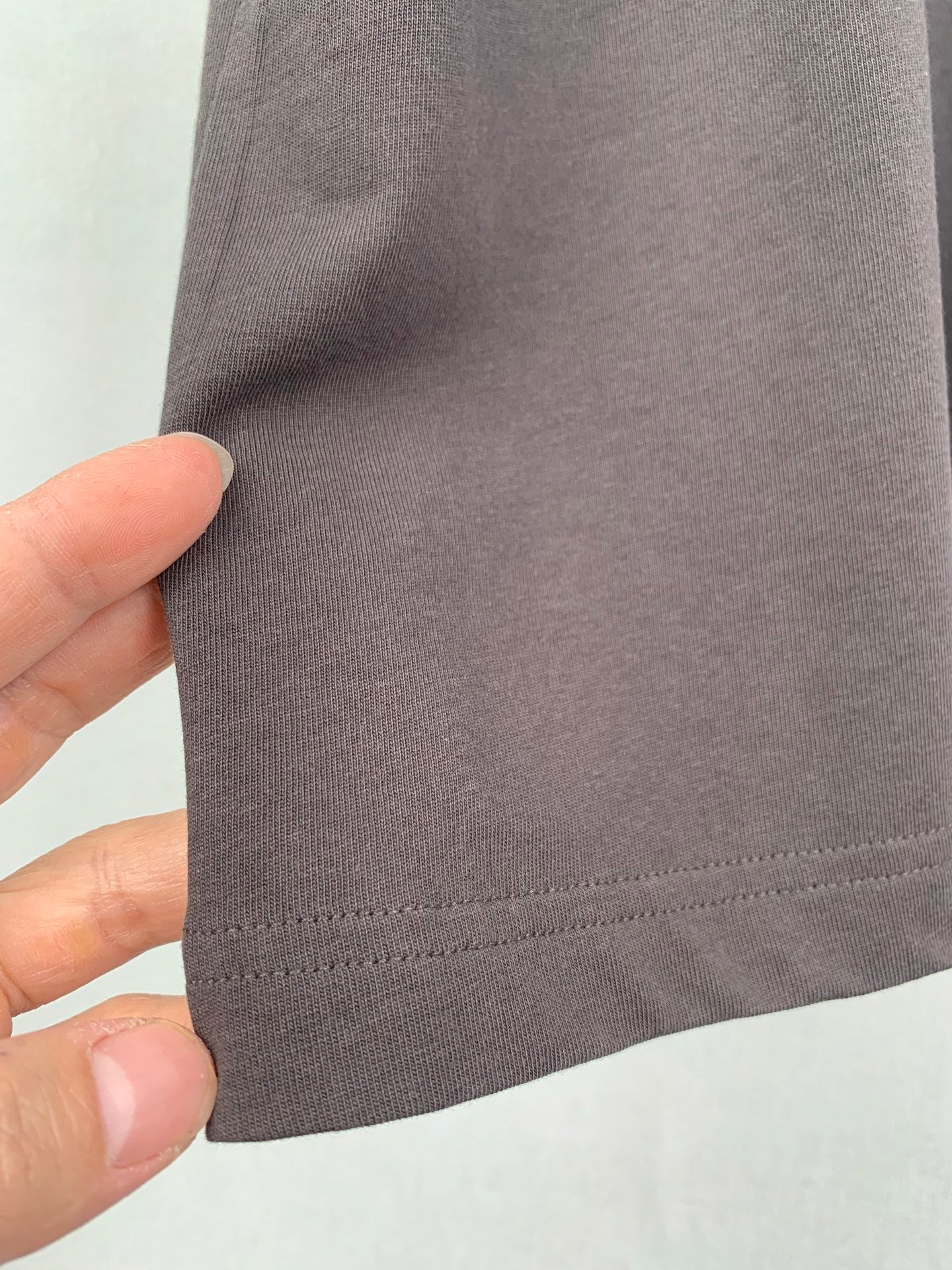 Dark T-shirt side seam and hem stitching close-up
