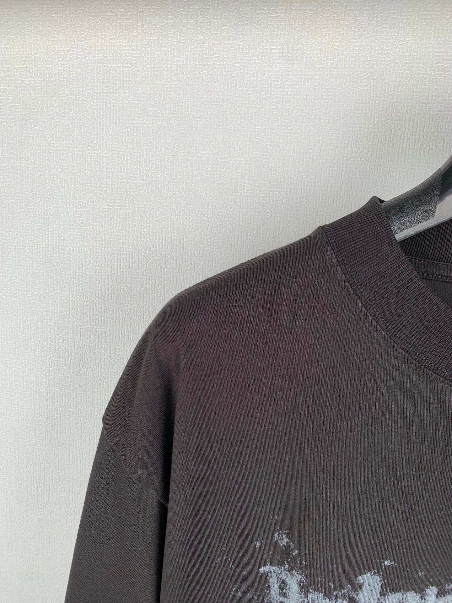 Dark crew-neck T-shirt shoulder and sleeve close-up with ribbed neckline