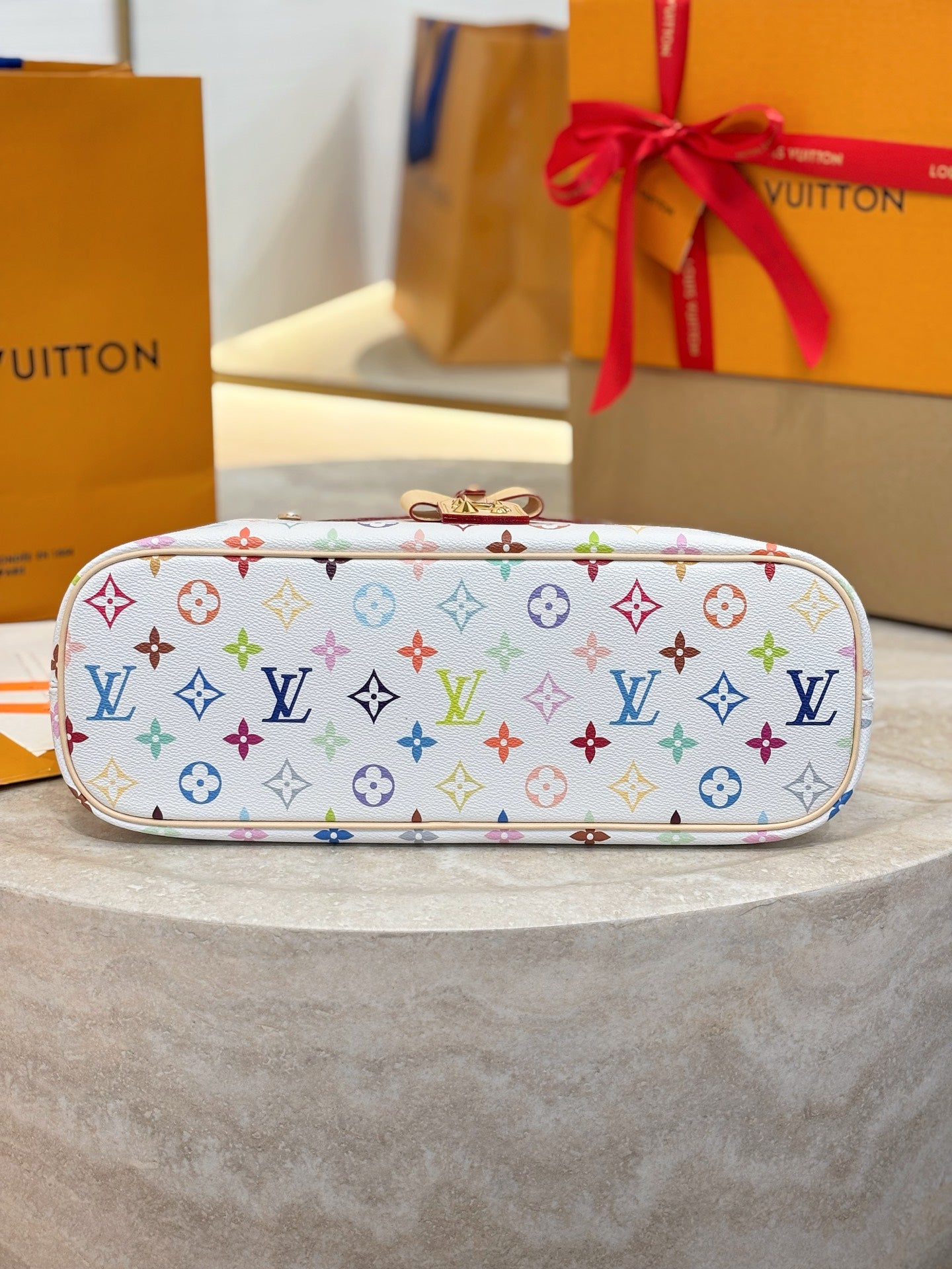 Side view of hobo bag in multicolor monogram canvas with top zip closure