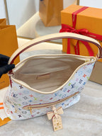 Hobo bag interior view with beige lining, front zip pocket, and key charm