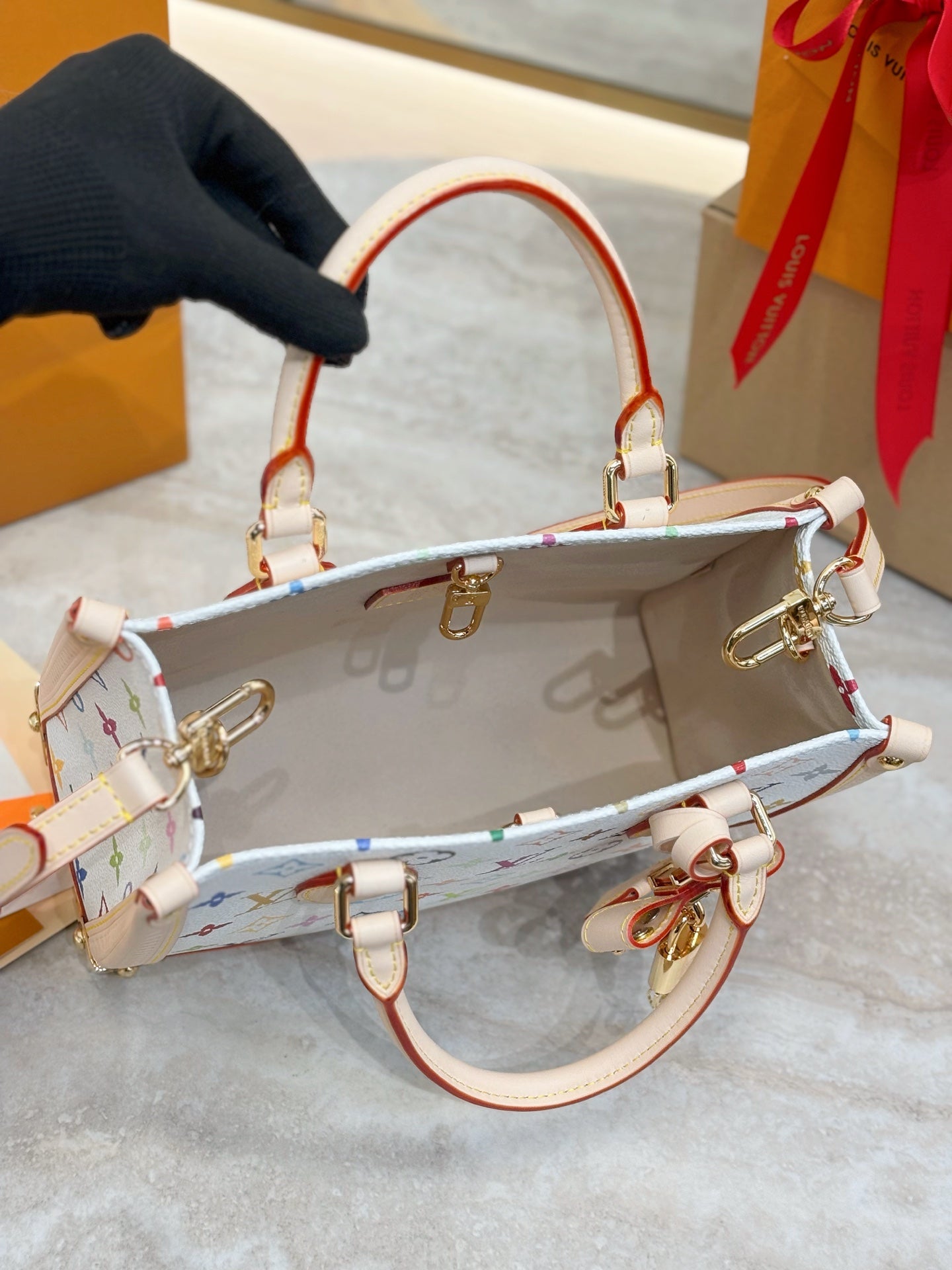 Multicolor monogram bag with red-and-white strap, open top, gold clasps