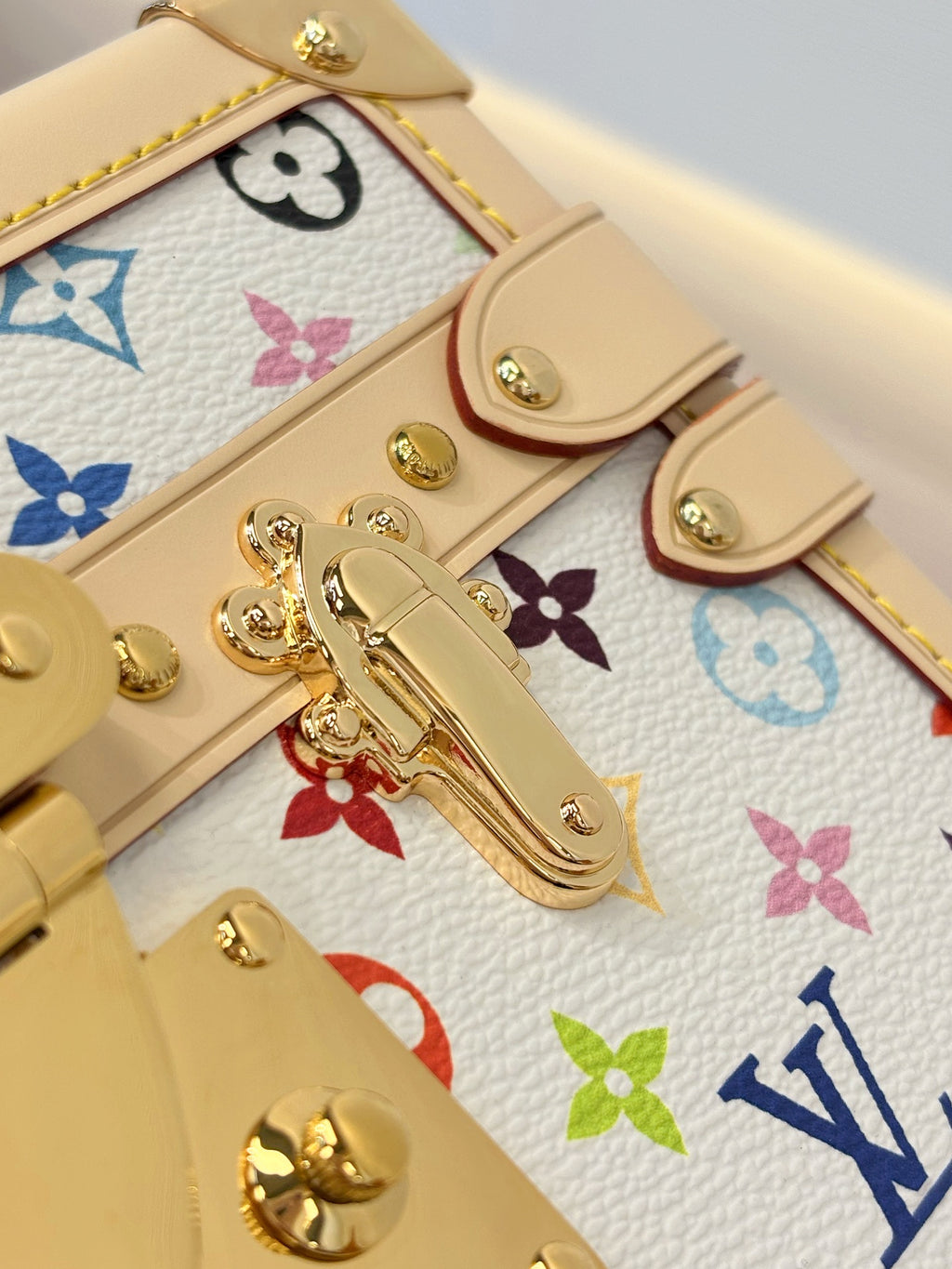 Louis Vuitton mini bag hardware close-up with gold clasps on multicolor Monogram canvas