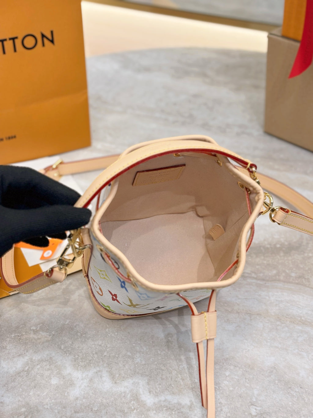 Louis Vuitton bag interior view with tan lining and zip opening, shown with strap