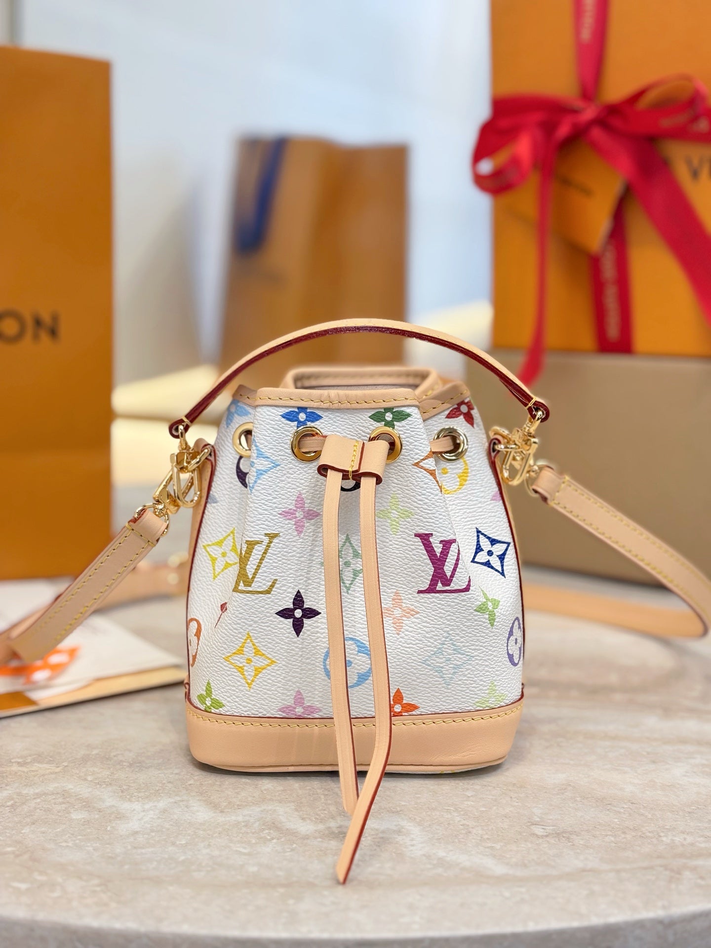 Louis Vuitton bag with multicolor monogram pattern, tan trim, and shoulder strap