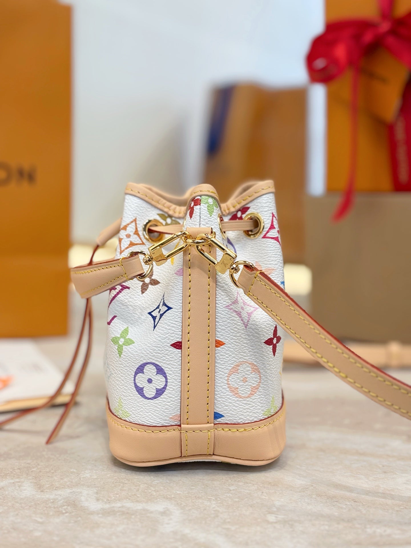 Louis Vuitton drawstring bag front with gold hardware and multicolor monogram pattern