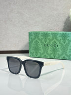 Gucci sunglasses with dark frames and smoke lenses