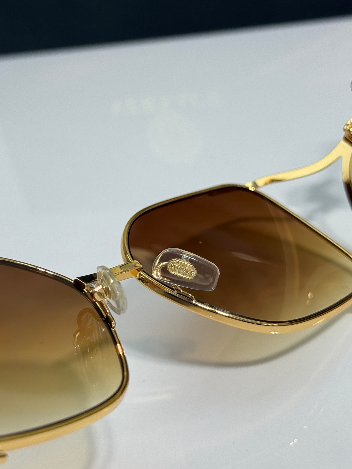 Versace sunglasses close-up, gold frame with amber tinted lenses